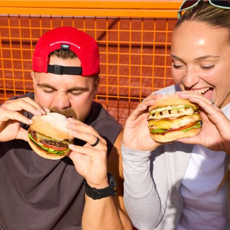 Couple eating Grill'd High Performance Range burgers